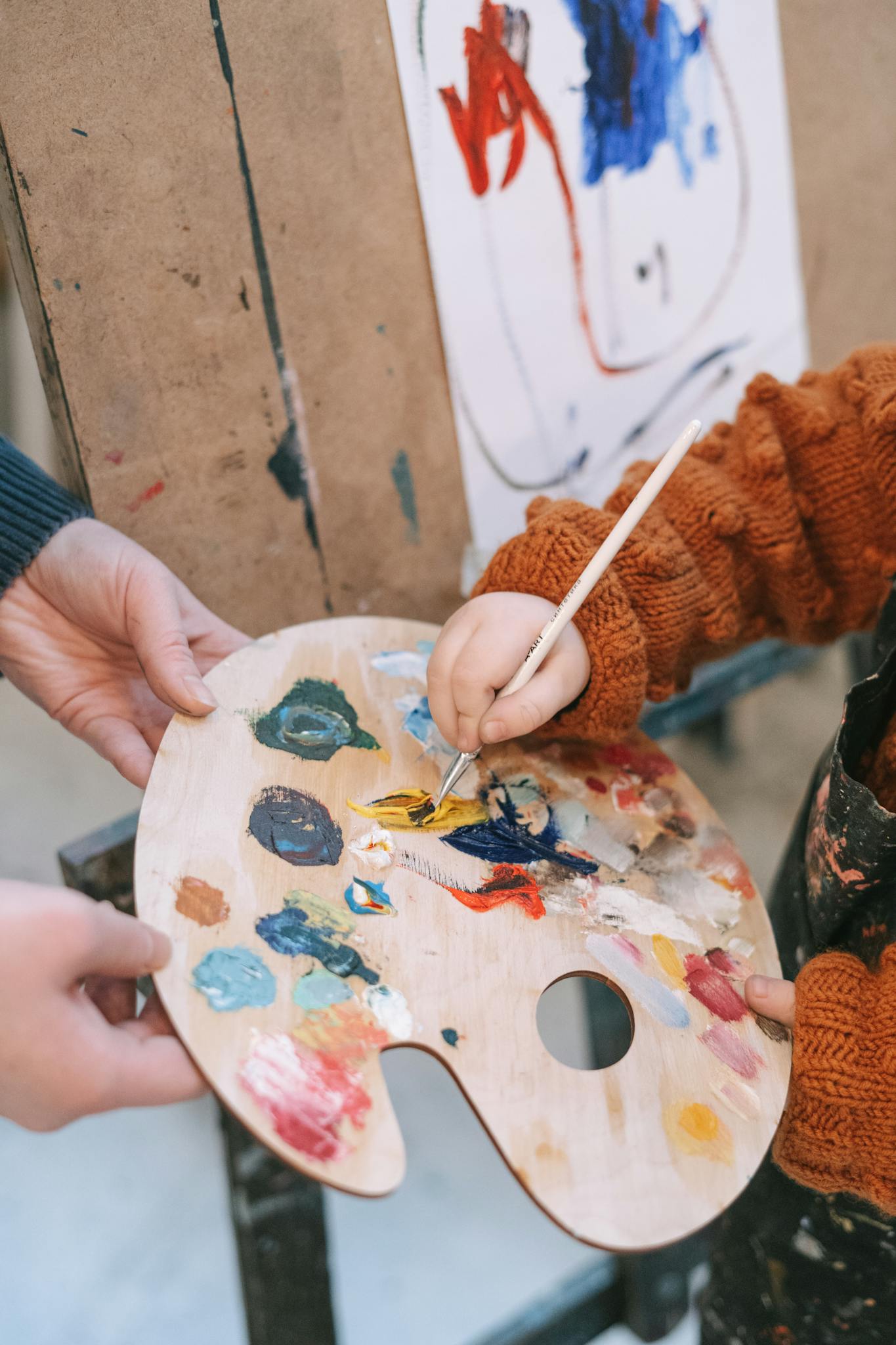 A child engaging in painting with a palette, highlighting creativity and learning.